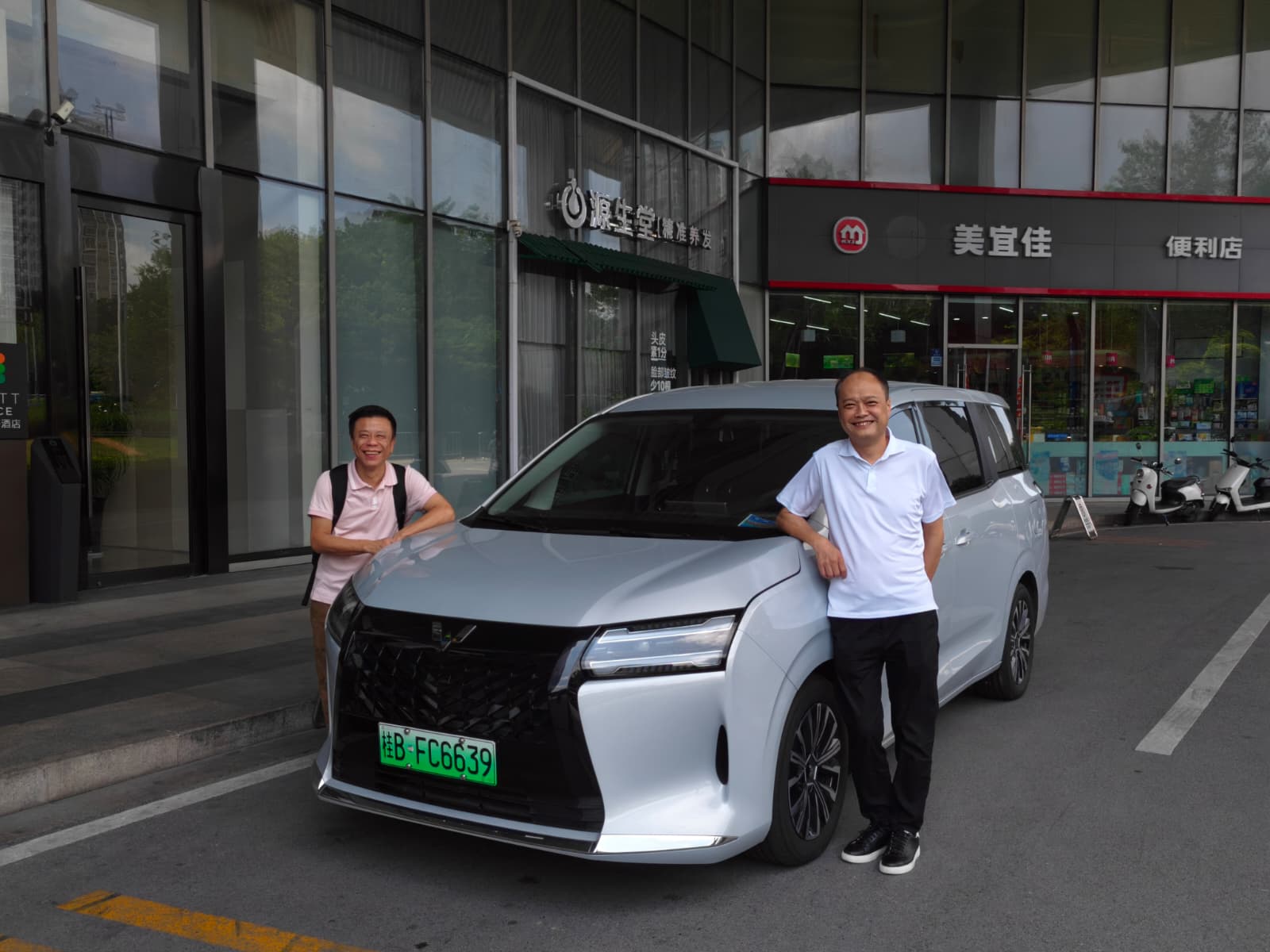 Delegation members reviewing a Wuling-related vehicle